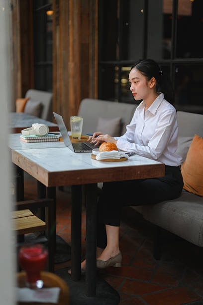 istock Young Asian woman remote working on laptop in cafe 2237356466