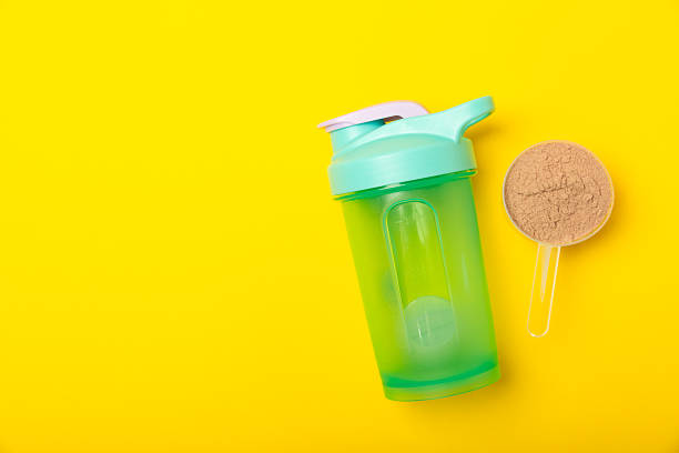 istock Protein shake with protein powder on a colored background. The powder is mixed with water or milk. A dietary supplement for a balanced diet. Whey protein. Fitness and gym diet nutrition. 2237357013