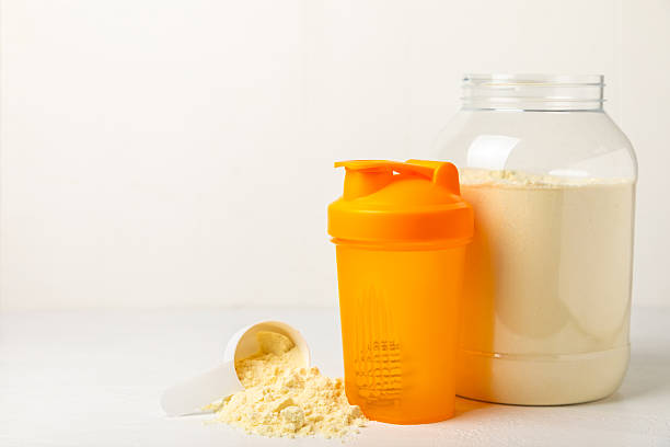 istock Protein shake with protein powder on a colored background. The powder is mixed with water or milk. A dietary supplement for a balanced diet. Whey protein. Fitness and gym diet nutrition. 2237357050