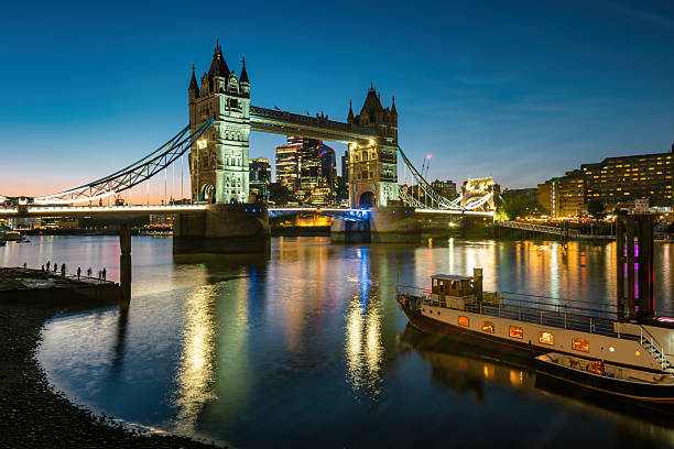 The Tower Bridge on the Thames waterfront in downtown London, UK, at twilight.