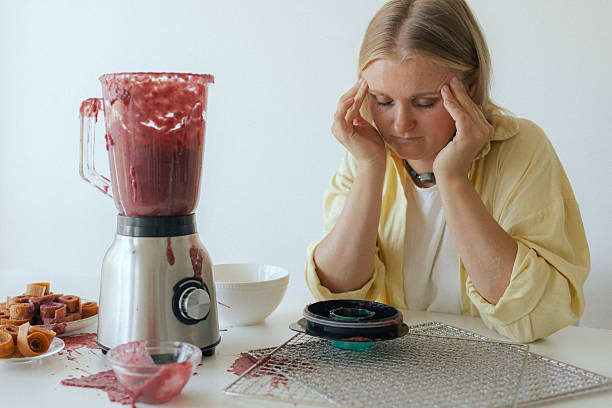 istock Close-up of a woman in her kitchen whose blender broke while making homemade fruit puree. The malfunction splattered fruit everywhere, leaving her surrounded by a messy scene instead of a healthy snack. 2237362928