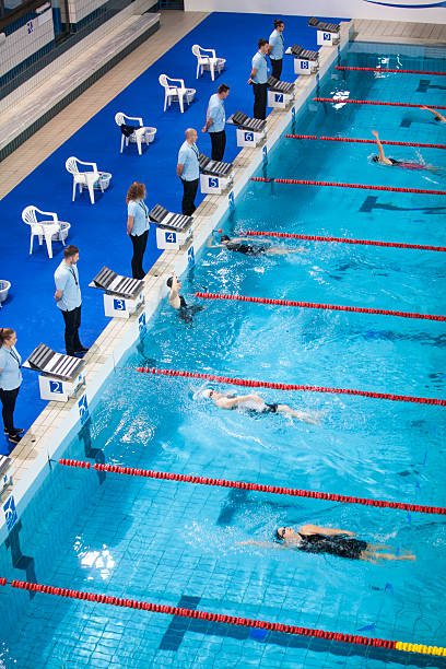 istock Competitive Swimmers and Officials at a Backstroke Race Finish 2237364881