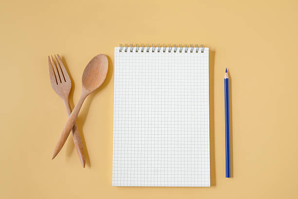 istock Wood spoon and fork with Recipe notebook on background. 2237367196