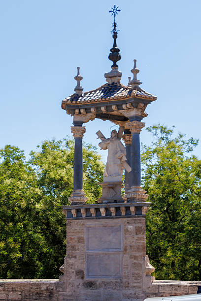 istock Statue of Saint Vincent Ferrer in Valencia, Spain, standing atop a decorative column under a blue sky, surrounded by lush greenery, symbolizing hope and heritage. 2237368377