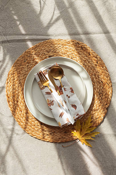 istock Table Setting with Yellow Leaves on White Plate and Woven Placemat under Sun Light 2237369743