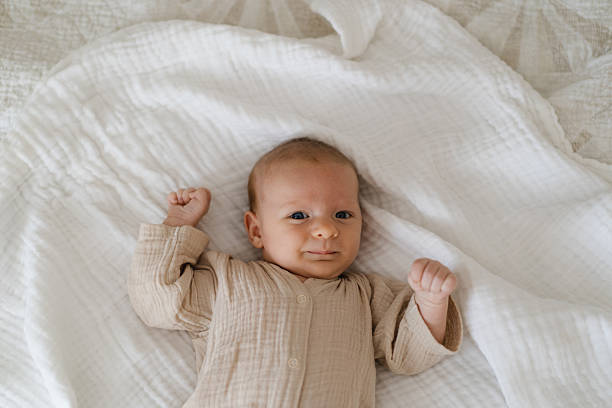 istock Cute baby lying on a soft white blanket. Newborn baby lying on bed 2237373348