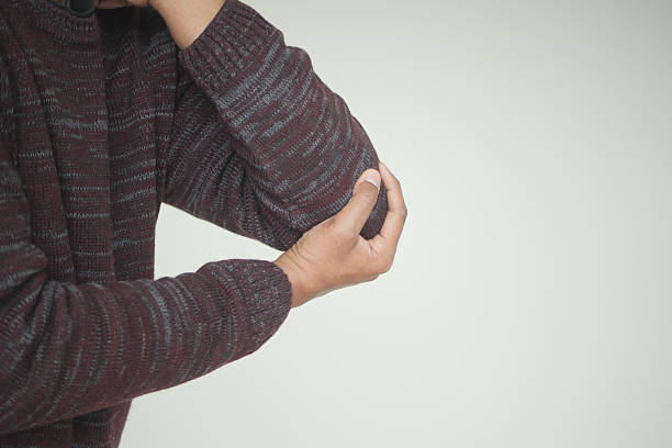 istock Person experiencing discomfort while holding elbow in casual setting 2237373852