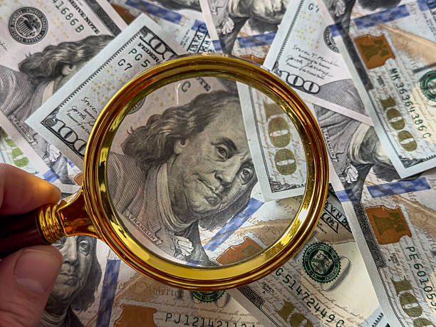 istock one hundred US dollar bills  under the magnifying glass 2237374032