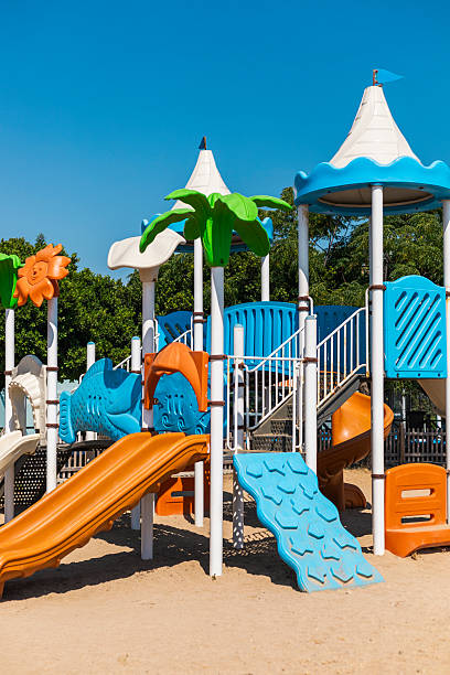 istock Brightly colored playground featuring multiple slides and climbing areas, surrounded by trees. Ideal spot for children to play and explore outdoors on a sunny day 2237379715