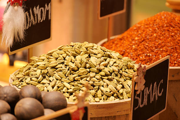 Piles of green cardamom, red sumac, and dark spices attract shoppers.