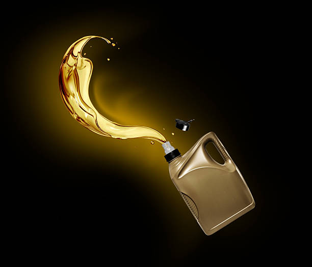 istock Splashes of engine oil pouring from a plastic container on a black background 2237383870