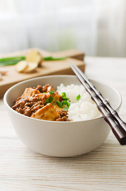 istock Mapo tofu dish in spicy sauce with minced beef in a ceramic bowl on a white background. Dish from Sichuan province. Traditional Asian food concept. Selective focus. Vertical orientation. 2237385765