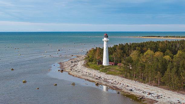 istock White lighthouse on rocky coastline with blue sea. 2237387623