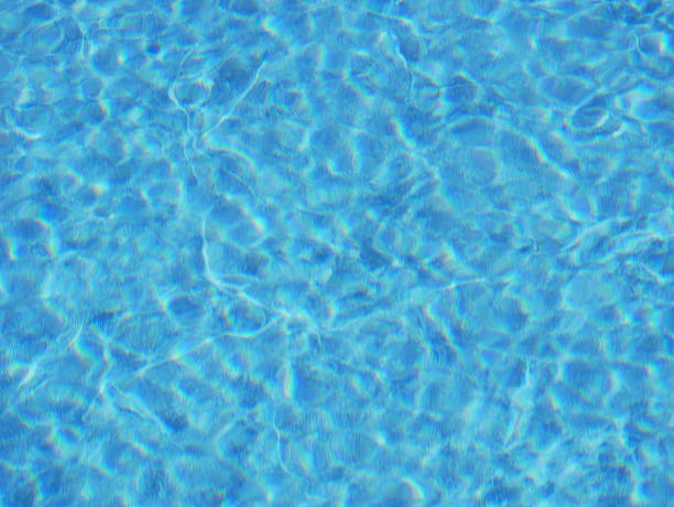 istock Clear Blue Swimming Pool Water Surface with Sunlight Reflections 2237390903