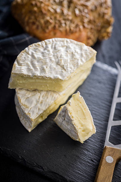 istock Camembert cheese on black table. French cheese with mold on the surface. 2237390904