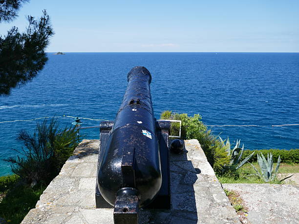 Old bartizan with a wooden door overlooking the foamy waves of the sea from a medieval fortress
