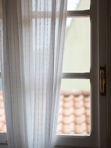 istock White curtain with a gold handle is hanging in front of a window 2237392320