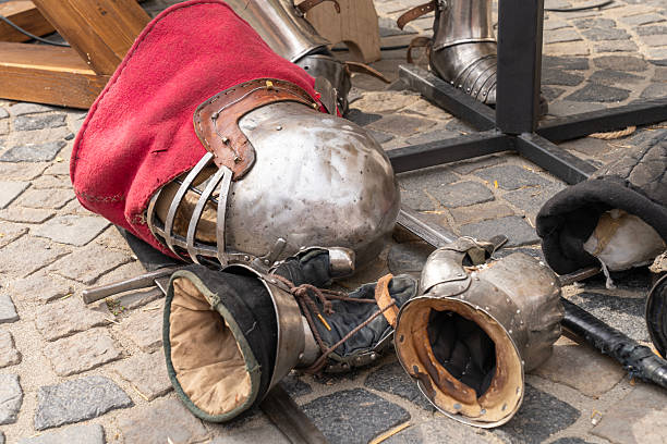 istock Medieval armor pieces and swords on cobblestone ground 2237395227