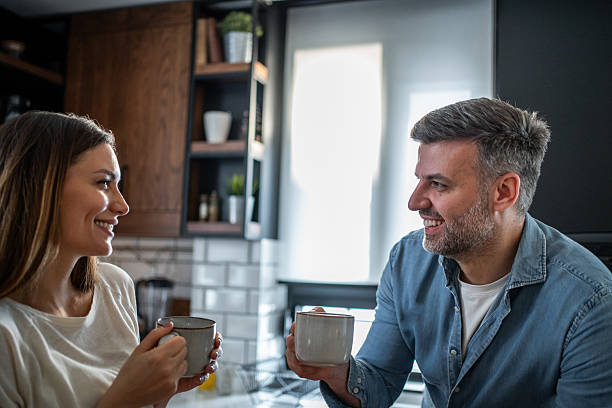 istock Happy couple enjoying morning coffee and conversation in kitchen 2237396444