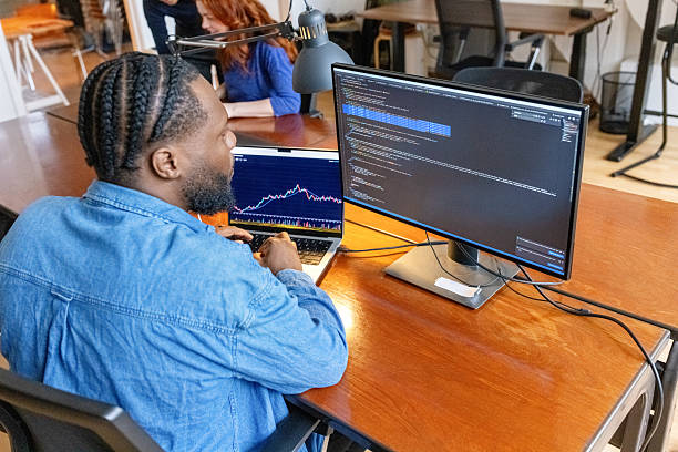 istock IT specialist reviewing trading analytics in contemporary workspace with laptop and computer monitor 2237401242
