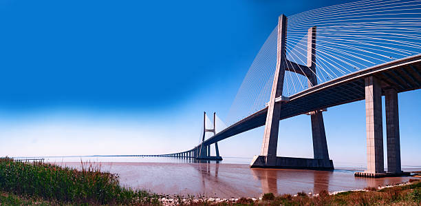 istock Vasco da Gama bridge over the Tagus river at sunset with sun and clouds. 2237401326