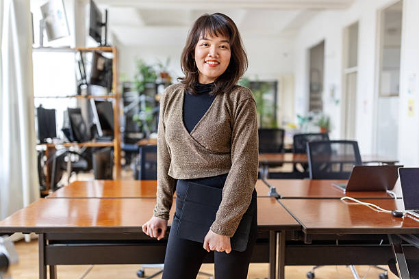 istock Confident Asian woman standing with tablet in startup office. 2237401419