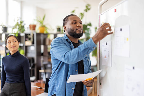 istock Young African businessman giving professional presentation to team 2237403849