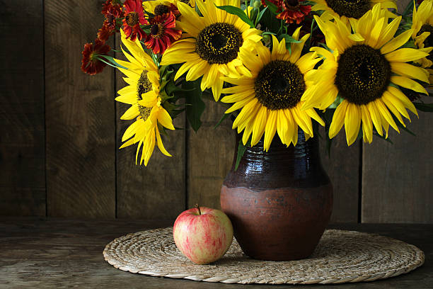 istock Sunflowers bouquet in rustic vase with apple 2237405765
