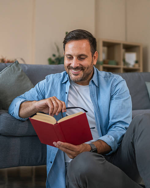 istock Man reading book in comfortable living room at home 2237412475