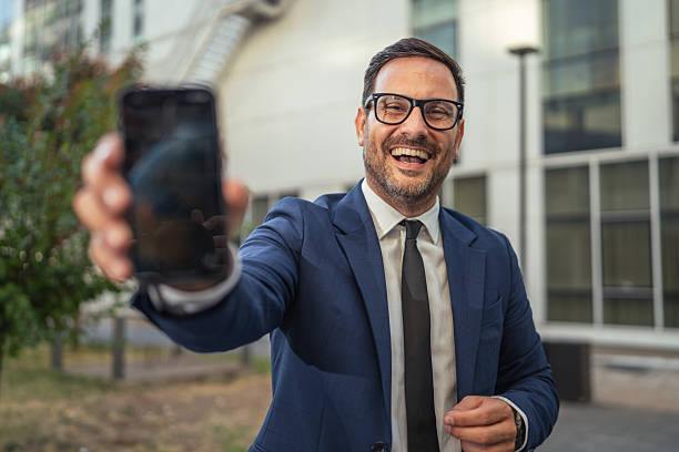istock Happy businessman showing smart phone screen in urban setting 2237412717