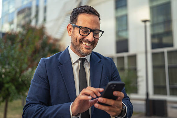 istock Businessman happily using mobile phone outdoors for communication 2237412728