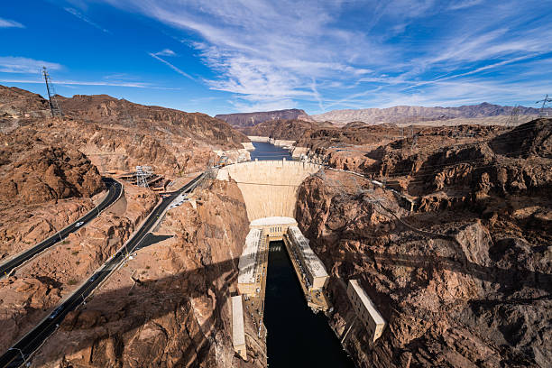 October 2024, Las Vegas, Nevada, United States: The Hoover Dam on the Colorado River is seen from above, showing the massive concrete structure, surrounding rocky desert landscape, and water flowing between the canyon walls.