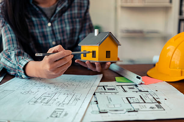 istock Architect checking blueprints on construction site Architects and engineers meet to discuss and check house plans to meet building and construction standards. 2237427956