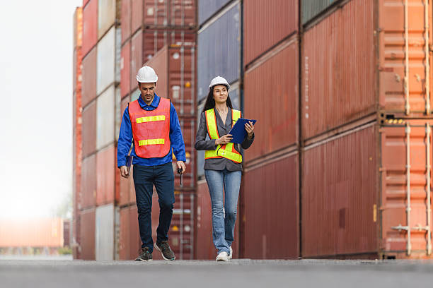 istock Logistics Managers Walk Through a Shipping Container Yard, Engineers Discussing Cargo Shipments at an Industrial Port, Professional Colleagues Inspecting Inventory at a Shipping Container Depot 2237428144