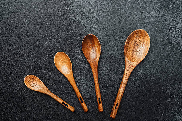istock Collection of wooden cooking spoons displayed on a dark surface for culinary use 2237429585