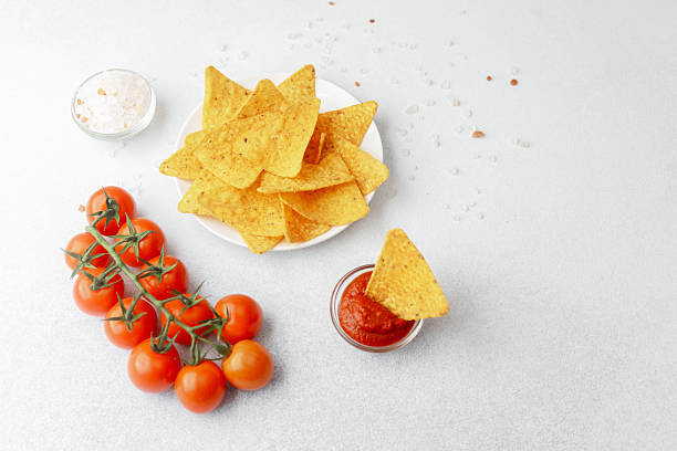 istock Nachos with tomato salsa, salt and fresh cherry tomatoes on white background 2237429642