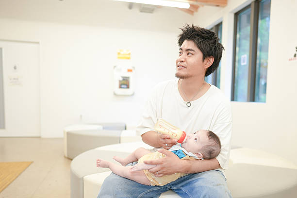 istock A man is holding a baby and feeding it from a bottle 2237431077