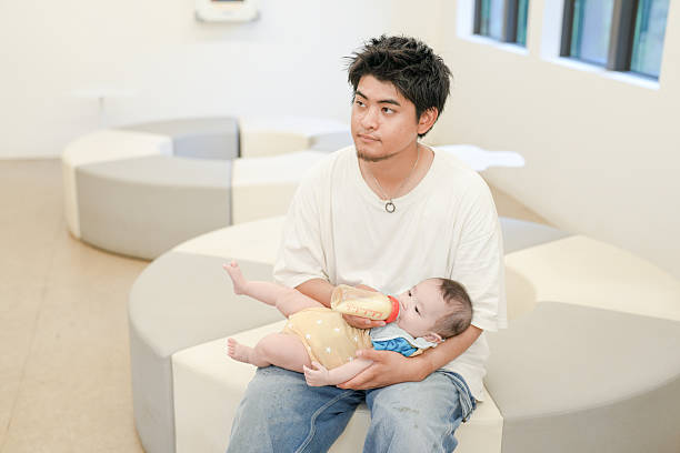 istock A man is holding a baby and feeding it from a bottle 2237431798