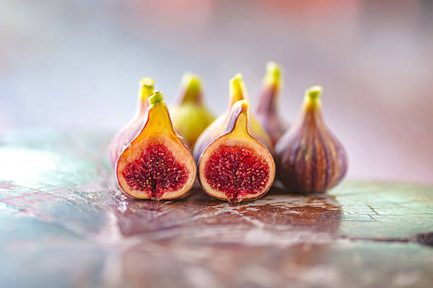 Fresh Figs Halved On Wooden Table Showcasing Rich Red Interior And Purple Skin,The Fig name is Called Col De Dame Mutant or CDDM