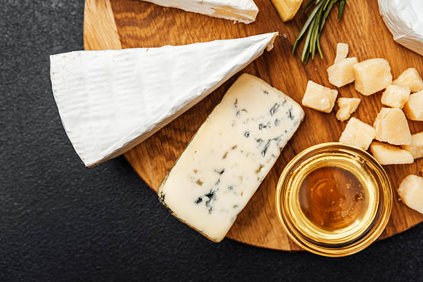 istock Cheese platter featuring assorted types and honey on wooden board 2237436653
