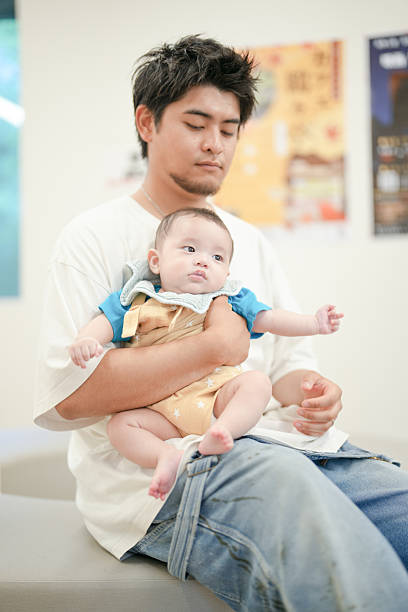 istock A man is holding a baby in his arms 2237439626