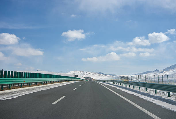 Scenic View of a Snowy Highway Under a Clear Blue Sky