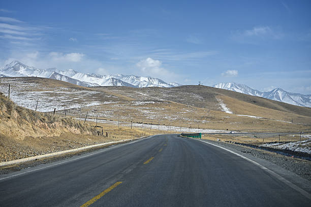 istock A Scenic Highway Stretching Towards Snow-Capped Mountains Under a Clear Blue Sky 2237441785
