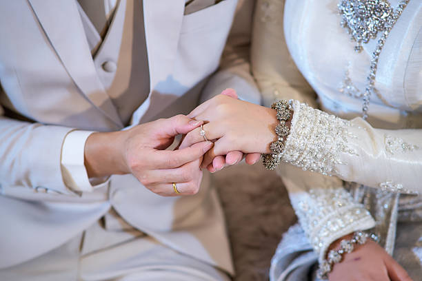 istock wedding rings together in hands 2237441873