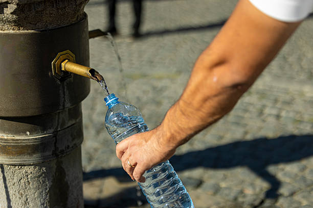 istock Filling a bottle with water from a street fountain 2237442392