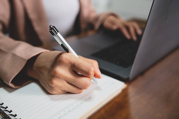 istock Company employee writing on notebook with working on laptop computer in office. Business planning concept 2237443015