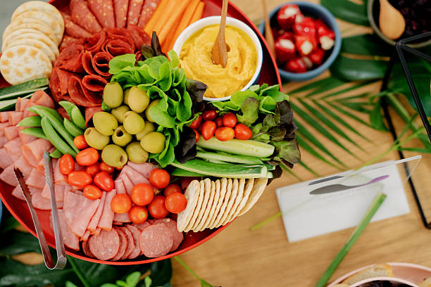 Close Up of Gourmet Buffet Table with Cheese, Fruit, Cold Cuts, Dipping Sauce, Olive and Decoration