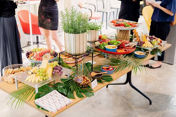 istock Gourmet Buffet Table with Cheese, Fruit, and Cold Cuts with Unrecognizable People in the Background 2237444811