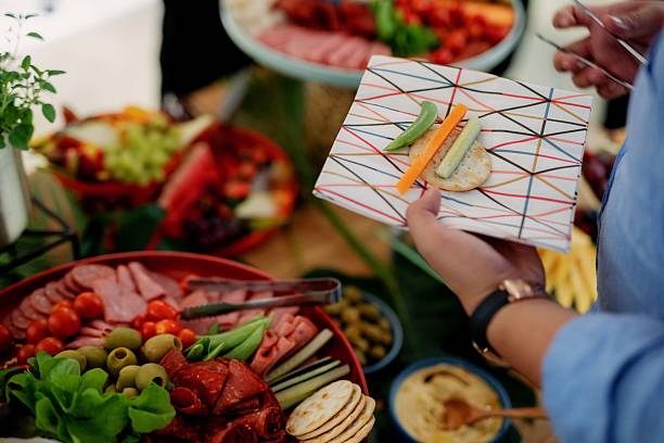 Close up of Hand Hands Holding a Small Appetizer Plate at a Buffet