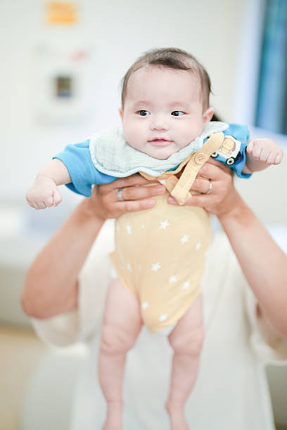 A baby is holding a toy airplane in its arms